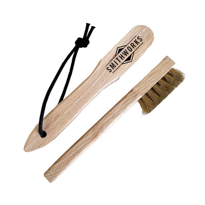 This picture shows a SmithWorks® Wooden Club Brass Brush with adjustable strap